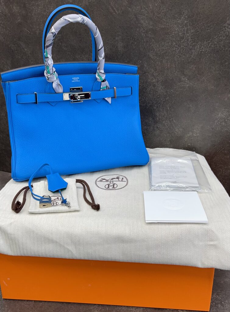 Blue Hermes Birkin bag with silver hardware and patterned twilly-wrapped handles