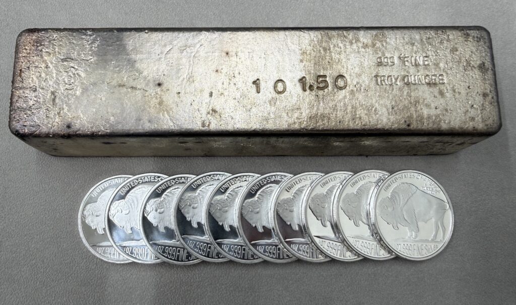 Large 101.5 troy ounce silver bar with a row of one-ounce silver Buffalo rounds